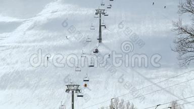 人们在冬季滑雪场的雪坡上滑雪和滑雪板。 雪山上的滑雪电梯。 冬季滑雪活动